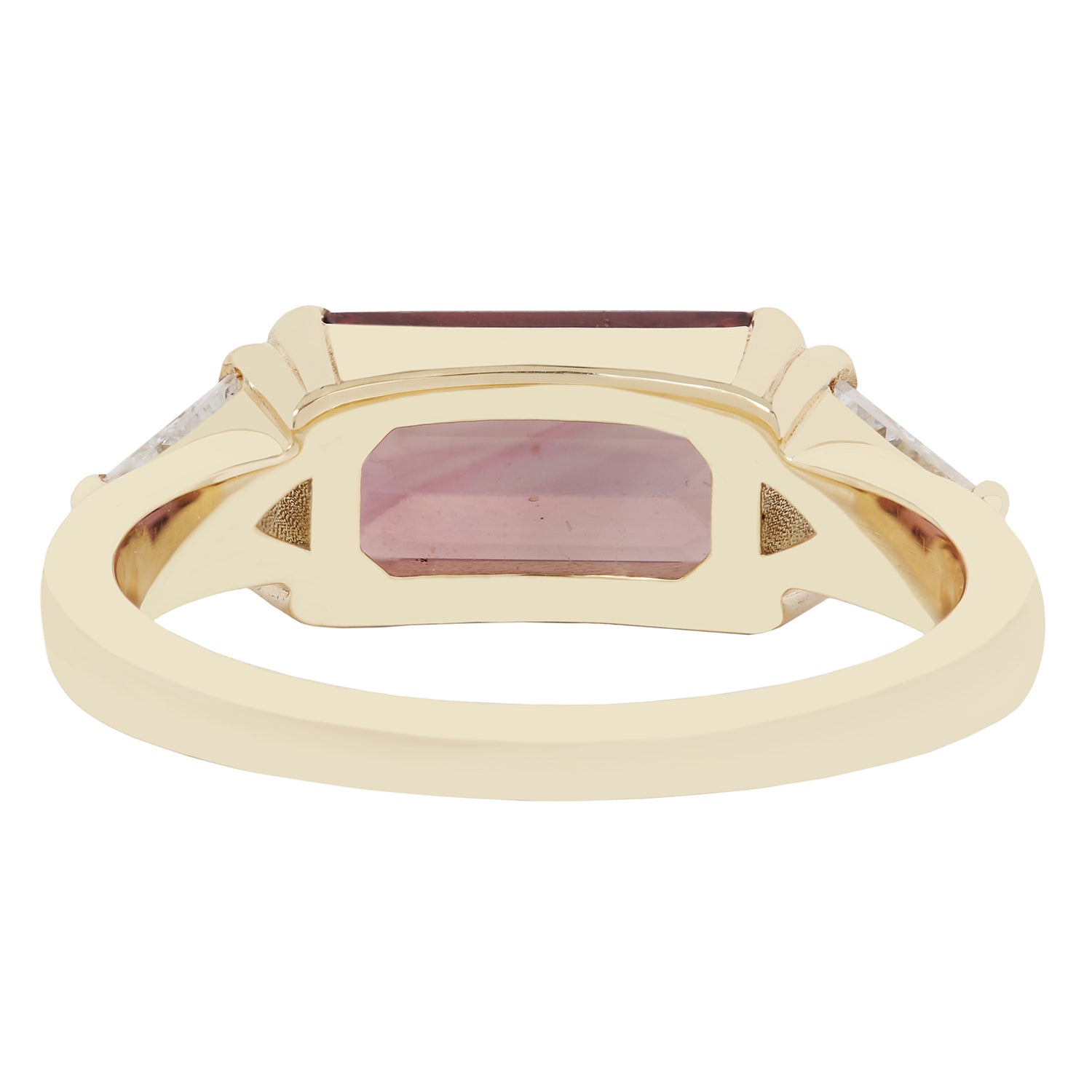 Gold ring with a rectangular maroon gemstone on a white background