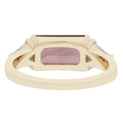 Gold ring with a rectangular maroon gemstone on a white background