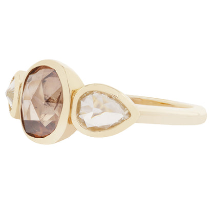 Gold ring with three gemstones on a white background