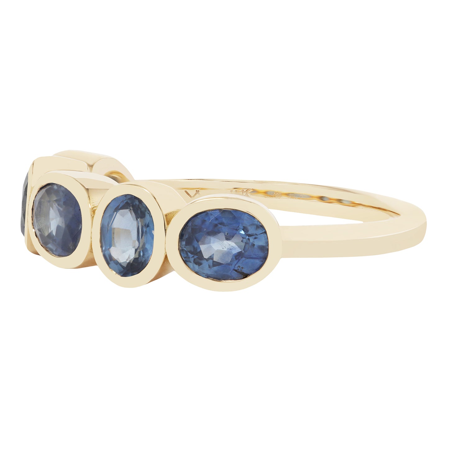 Gold ring with three blue gemstones on a white background