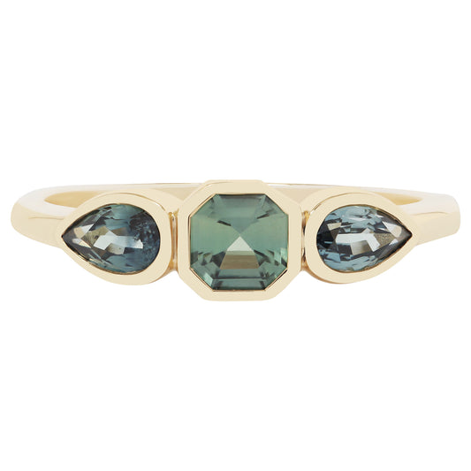 Gold ring with green gemstones on a white background