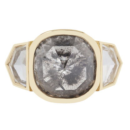 Gold ring with large central gray diamons and two smaller clear diamonds on a white background