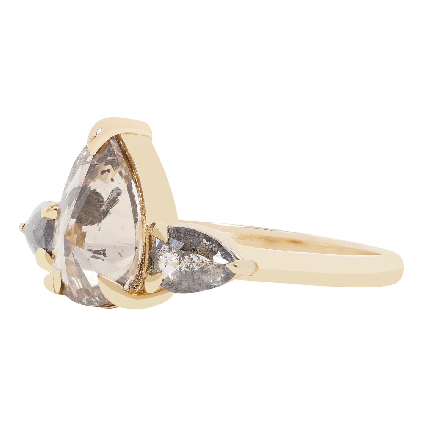 A gold ring featuring a large pear-cut clear diamond with inclusions, accented by two smaller marquise-cut gray diamonds on either side, shown on a plain white background.