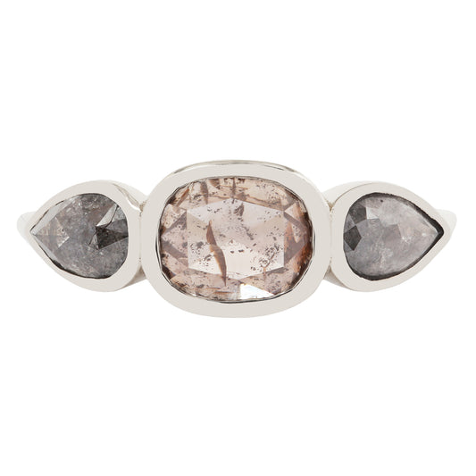 White gold ring with three pear-shaped gemstones on a white background