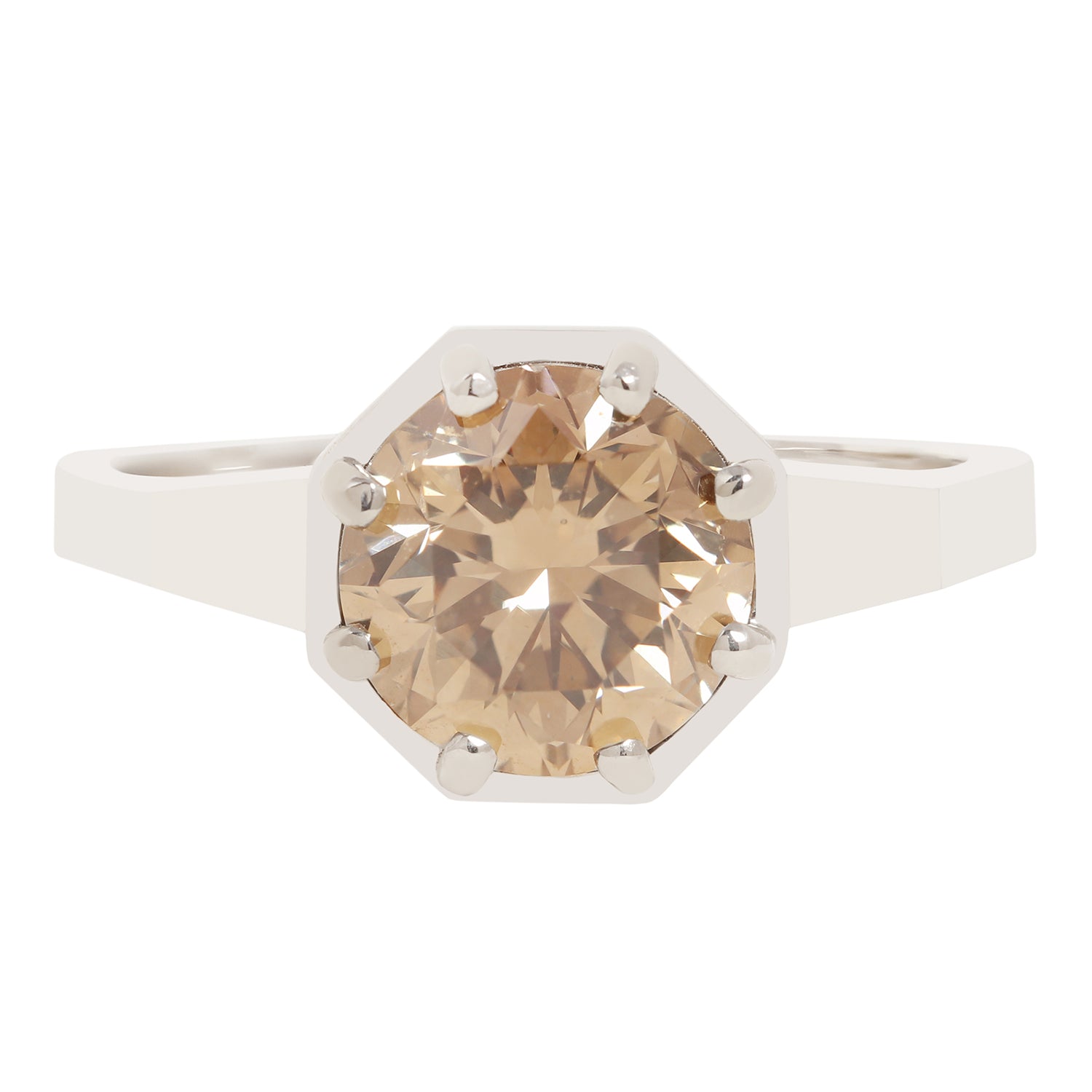 An octagonal solitaire ring featuring a large, round-cut champagne-colored gemstone in a white metal setting with prong holds, shown against a plain white background.