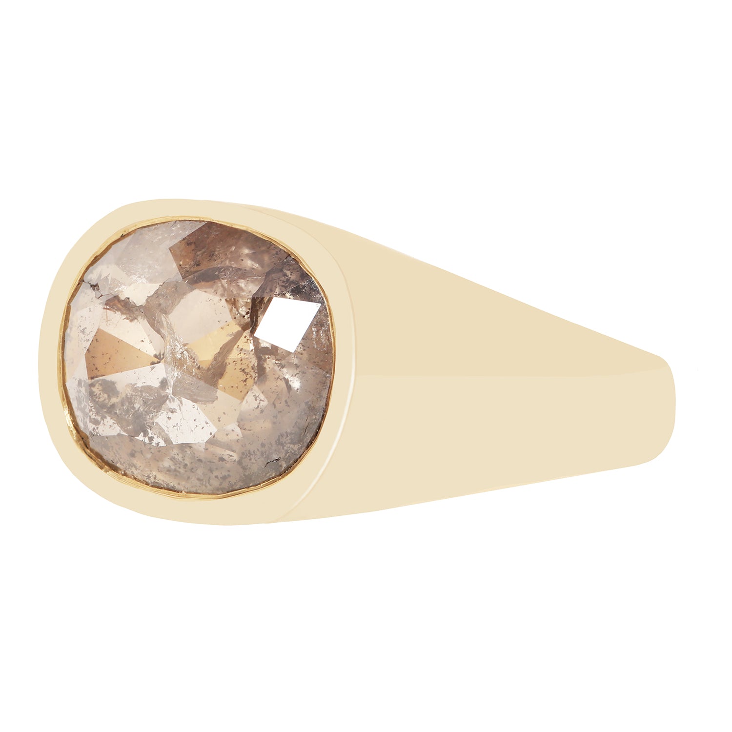 A signet-style ring with a wide, smooth champagne-gold band and a large, cushion-cut rough diamond center stone showing brown, gray, and white crystalline inclusions.