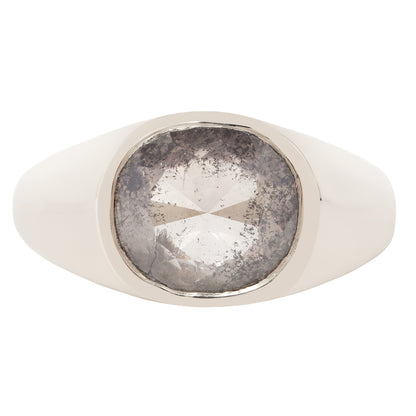 A silver signet ring featuring a large, round, heavily textured gray gemstone in a polished white gold bezel setting, shown against a plain white background.