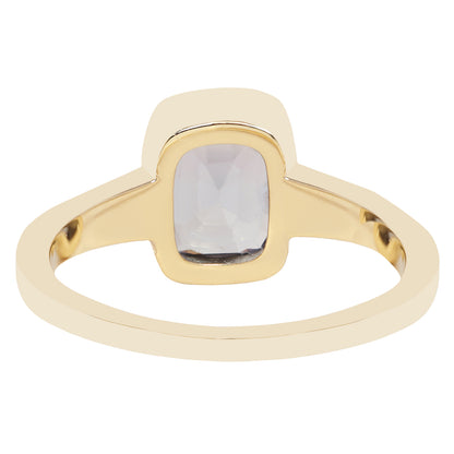 Bezel set solitaire yellow gold ring with a dark blue spinel rectangular stone on white background. 