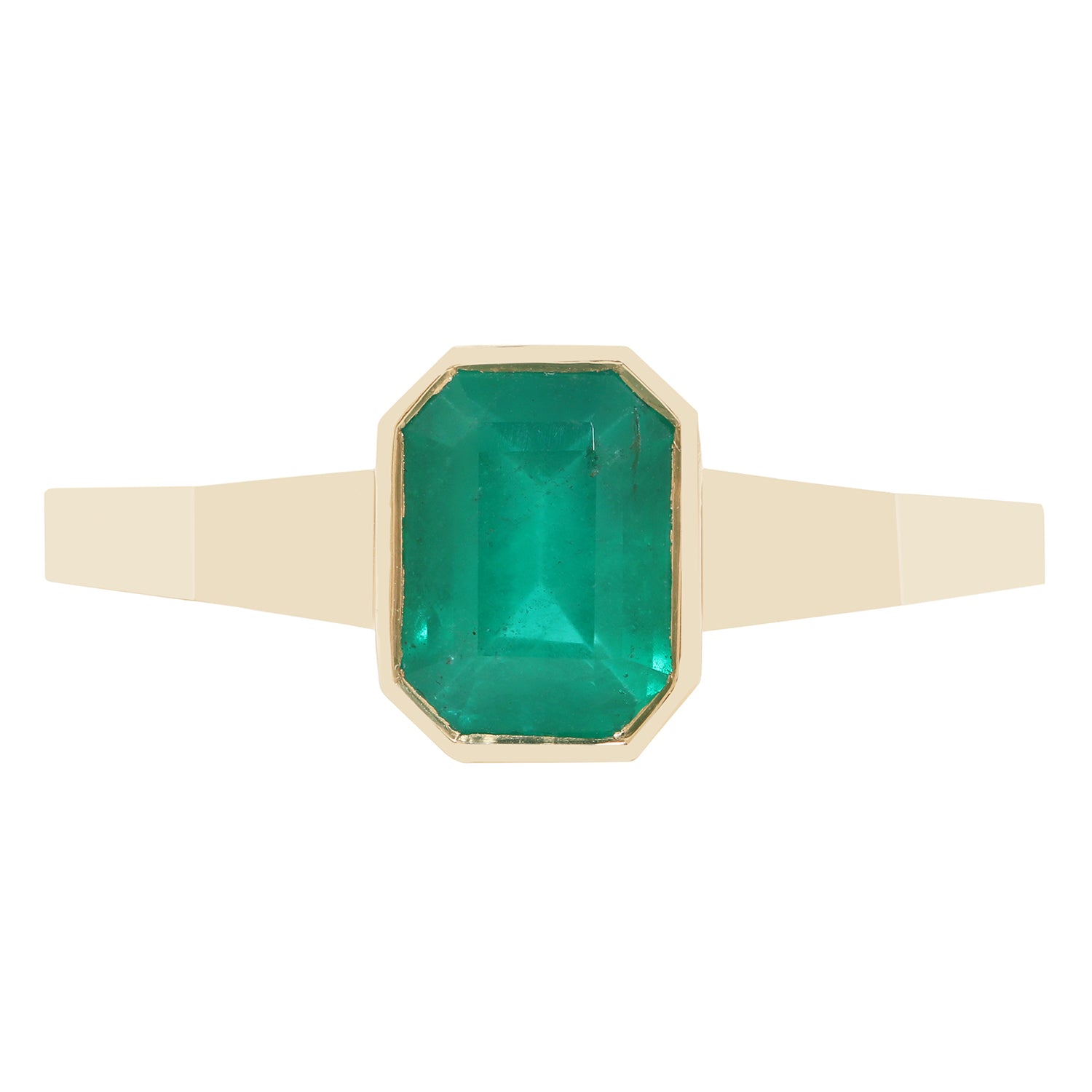 A close-up of a gold ring with a rectangular green gemstone, set against a plain white background.