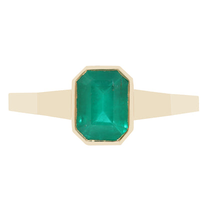 A close-up of a gold ring with a rectangular green gemstone, set against a plain white background.