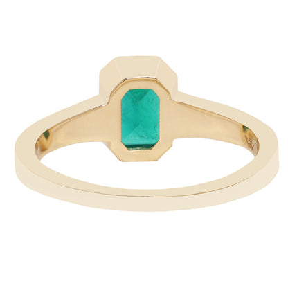 A close-up of a gold ring with a rectangular green gemstone, set against a plain white background.