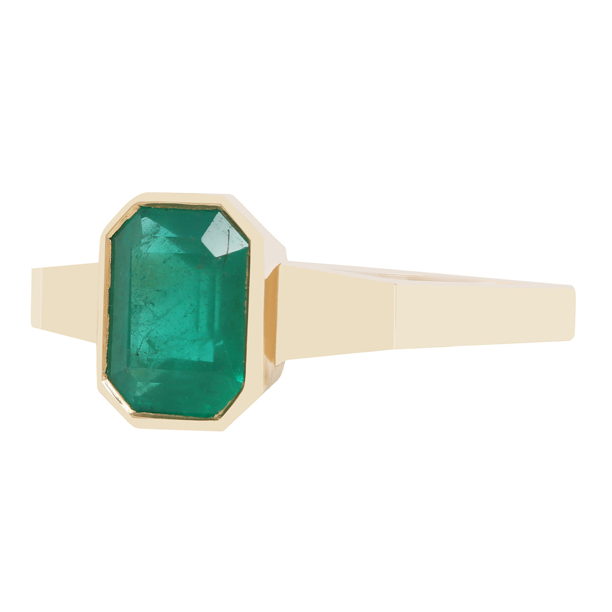A close-up of a gold ring with a rectangular green gemstone, set against a plain white background.