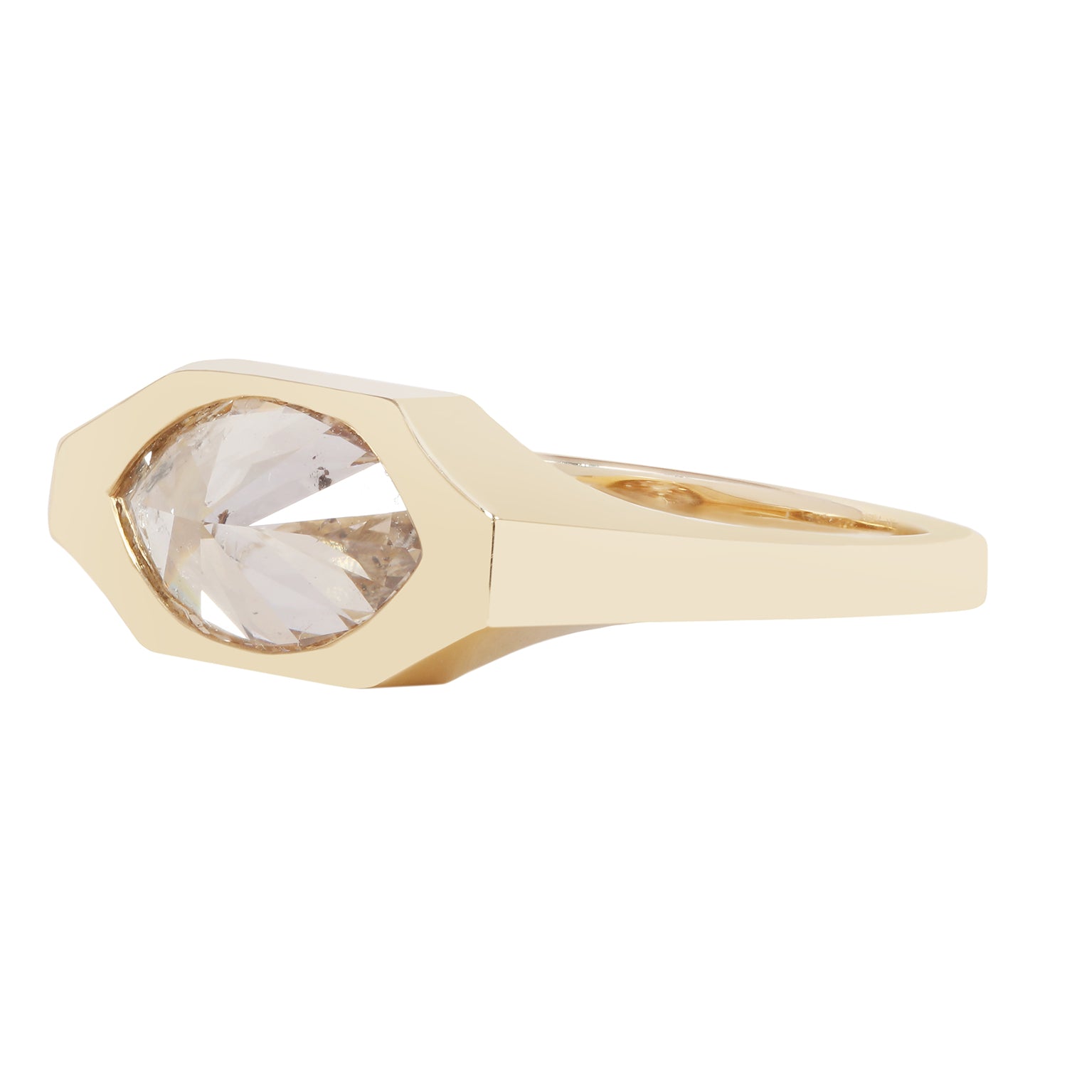 A geometric gold ring featuring a large, faceted clear gemstone in an octagonal bezel setting, shown against a plain white background.