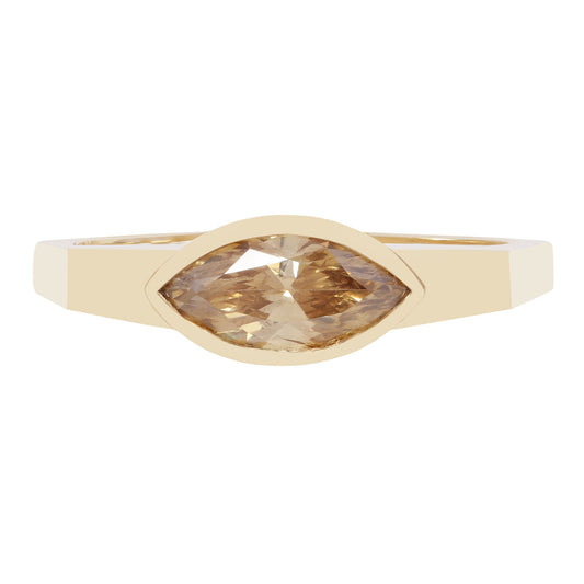 A yellow gold ring featuring a marquise-cut champagne-colored gemstone in a bezel setting, shown against a plain white background.