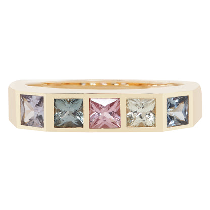 A yellow gold eternity ring featuring five square-cut gemstones in alternating pastel shades of lavender, blue-green, pink, clear, and blue, set against a plain white background.