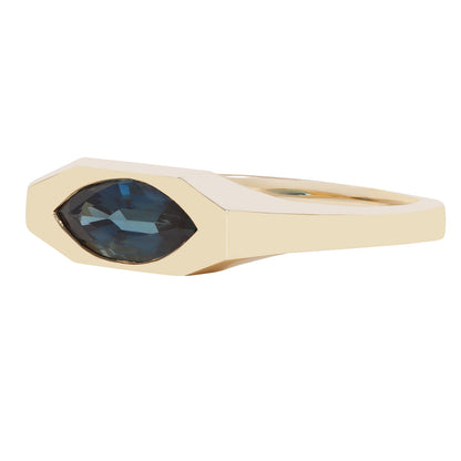 A gold ring featuring a marquise-cut dark blue gemstone in a geometric bezel setting, shown against a plain white background.