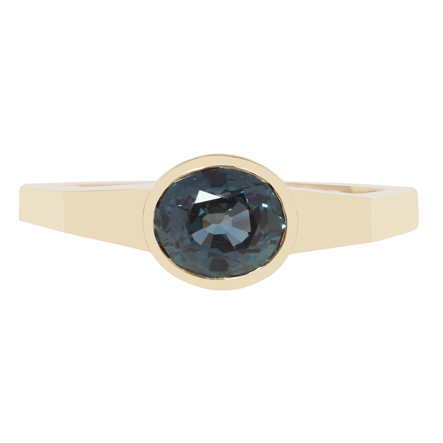 A gold ring with a round bezel-set dark blue-gray gemstone, shown against a plain white background.