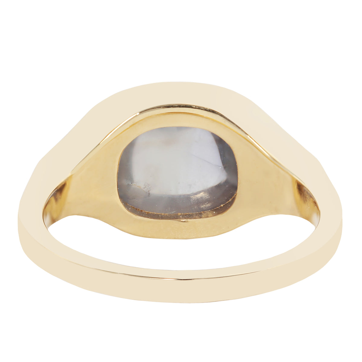 A gold signet ring with a wide, wavy, organic-shaped bezel holding a smooth, oval, milky white gemstone, shown on a plain white background.
