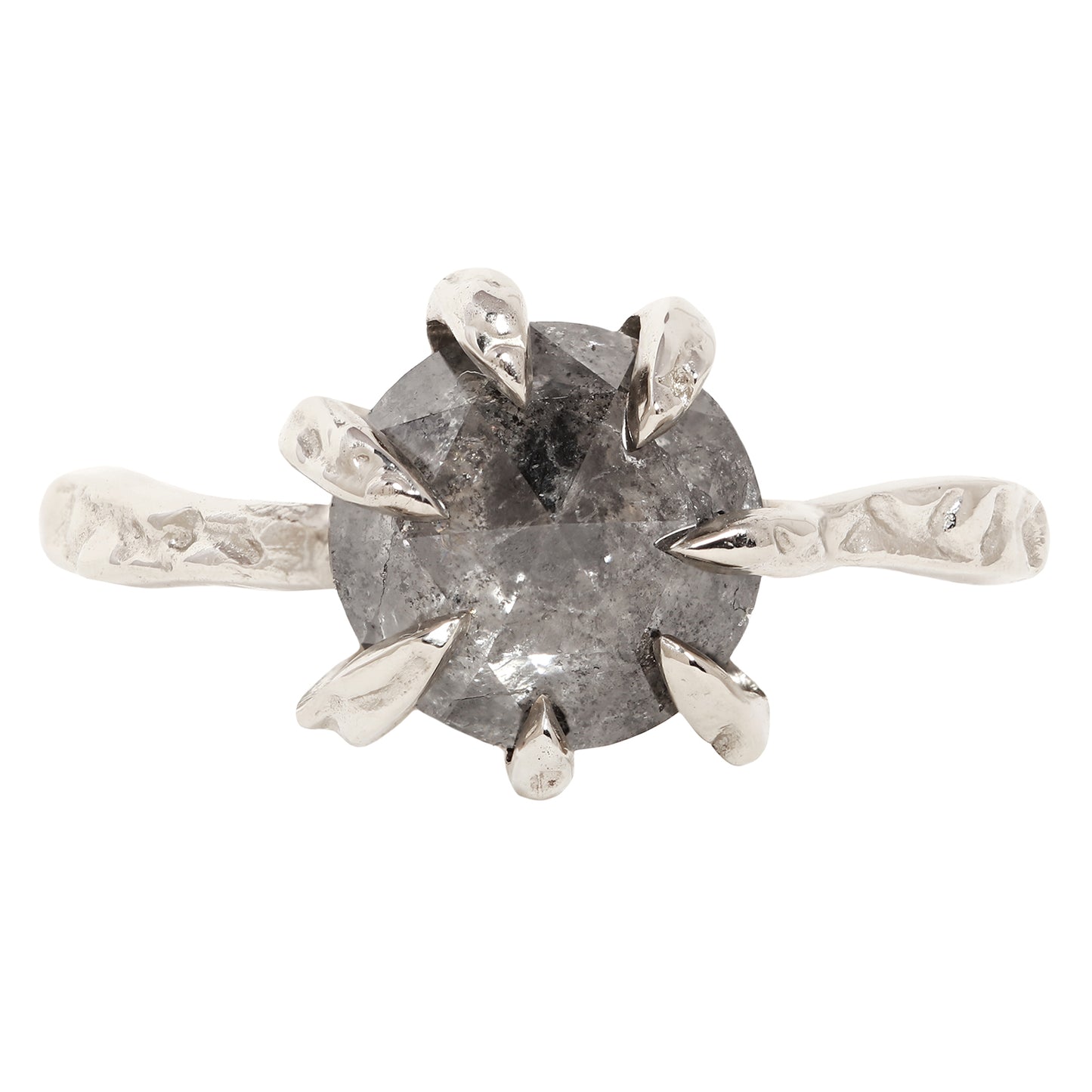 A unique white gold ring featuring a large, round, faceted gray gemstone held in a six-prong setting with textured, leaf-like prongs, mounted on a matching textured band.