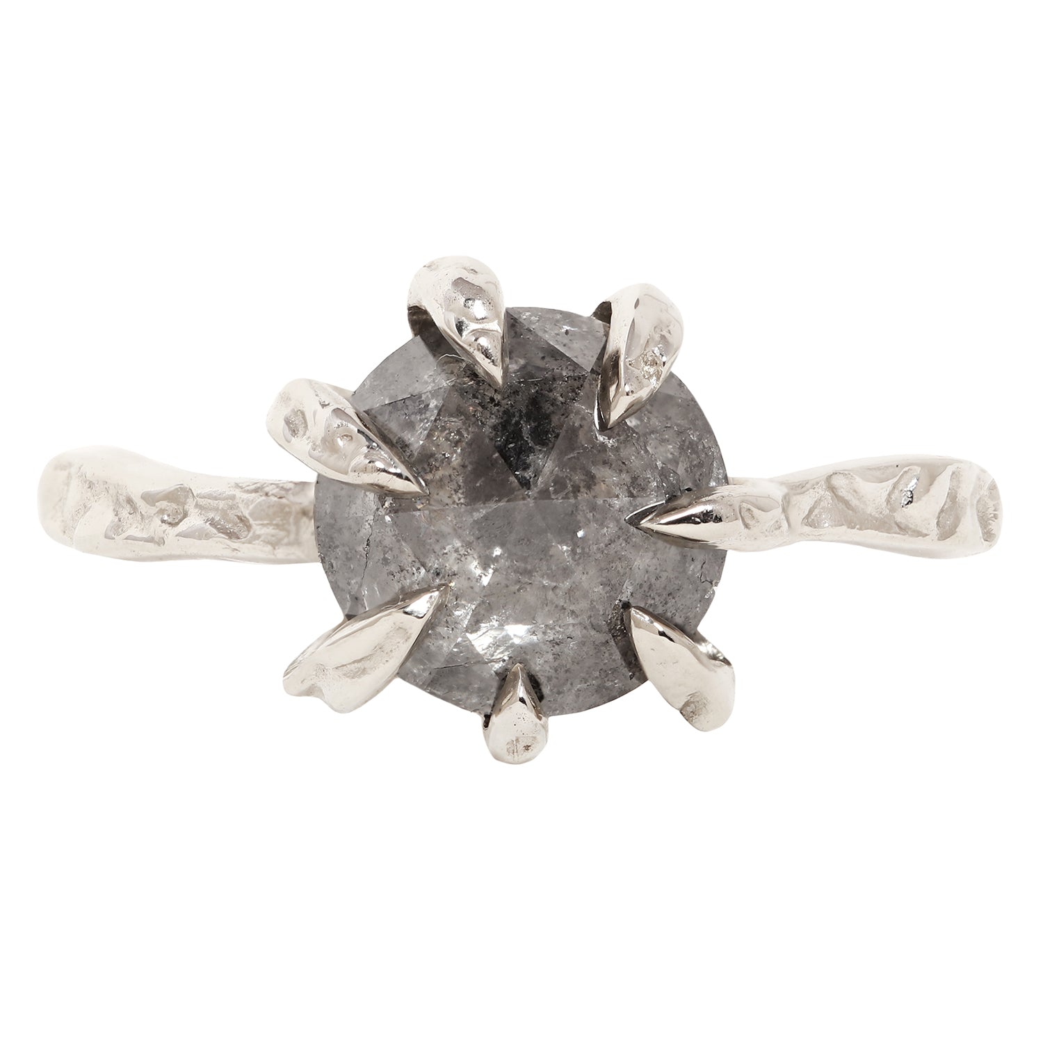 A unique white gold ring featuring a large, round, faceted gray gemstone held in a six-prong setting with textured, leaf-like prongs, mounted on a matching textured band.