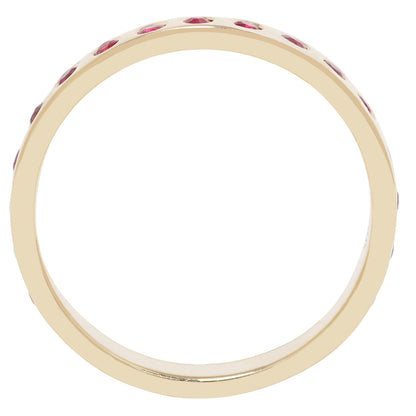 A yellow gold eternity ring featuring a continuous row of small round-cut red gemstones set around the band, shown against a solid white background.
