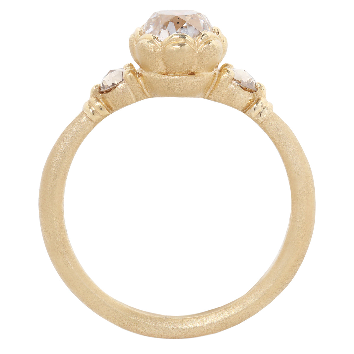 A gold ring featuring a large, round-cut clear gemstone surrounded by a decorative border of small gold beads, set on a smooth gold band against a plain white background.
