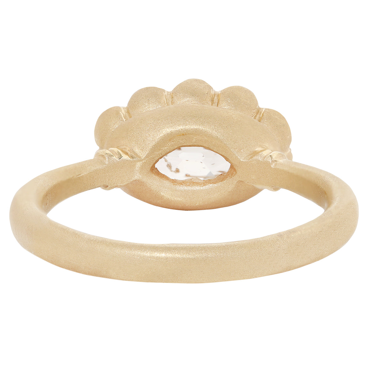 A textured yellow gold ring featuring a scalloped eye-shaped bezel with a clear, faceted gemstone in the center, set against a plain white background.