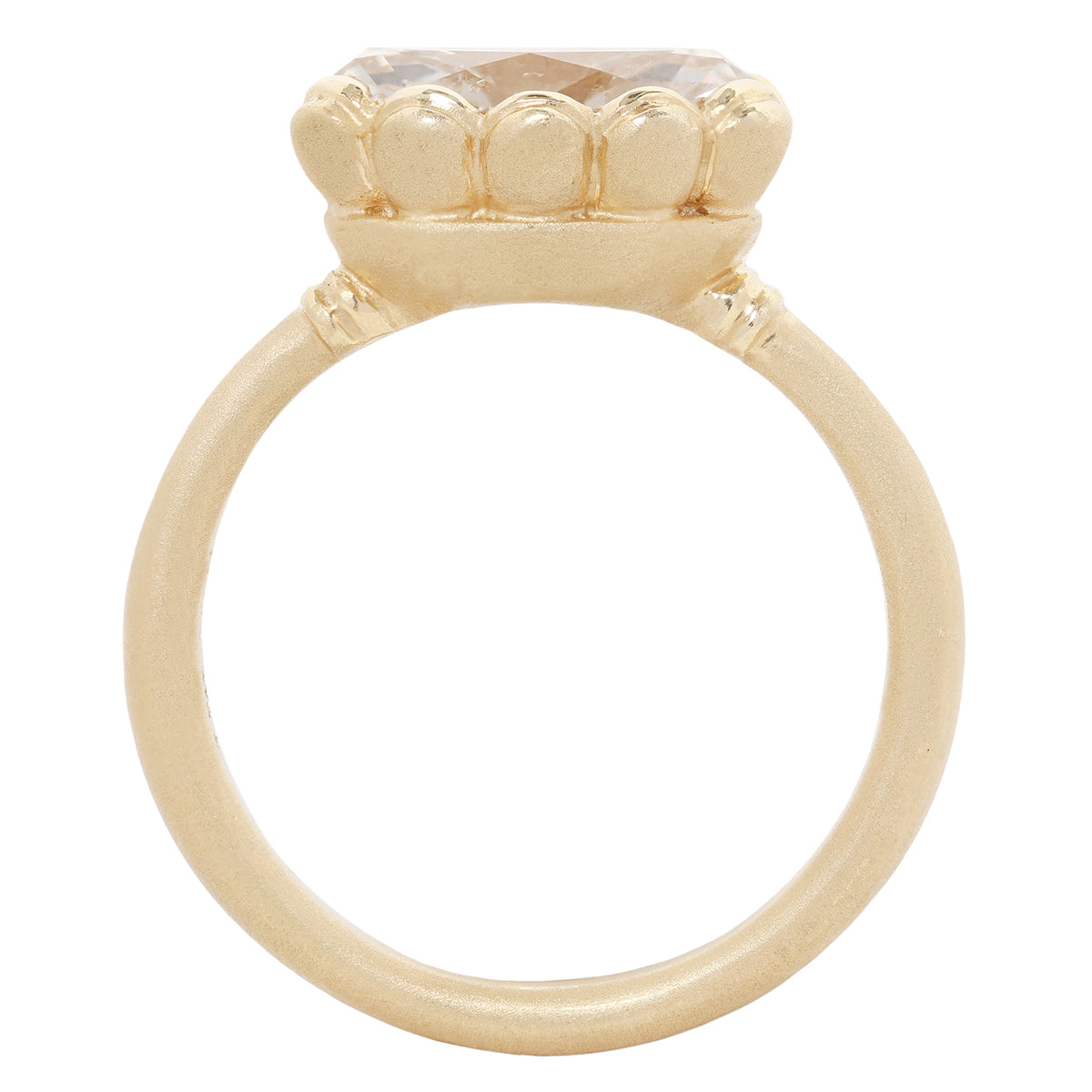 A gold ring with a large, round gemstone in a textured, flower-like crown setting, shown against a plain white background.