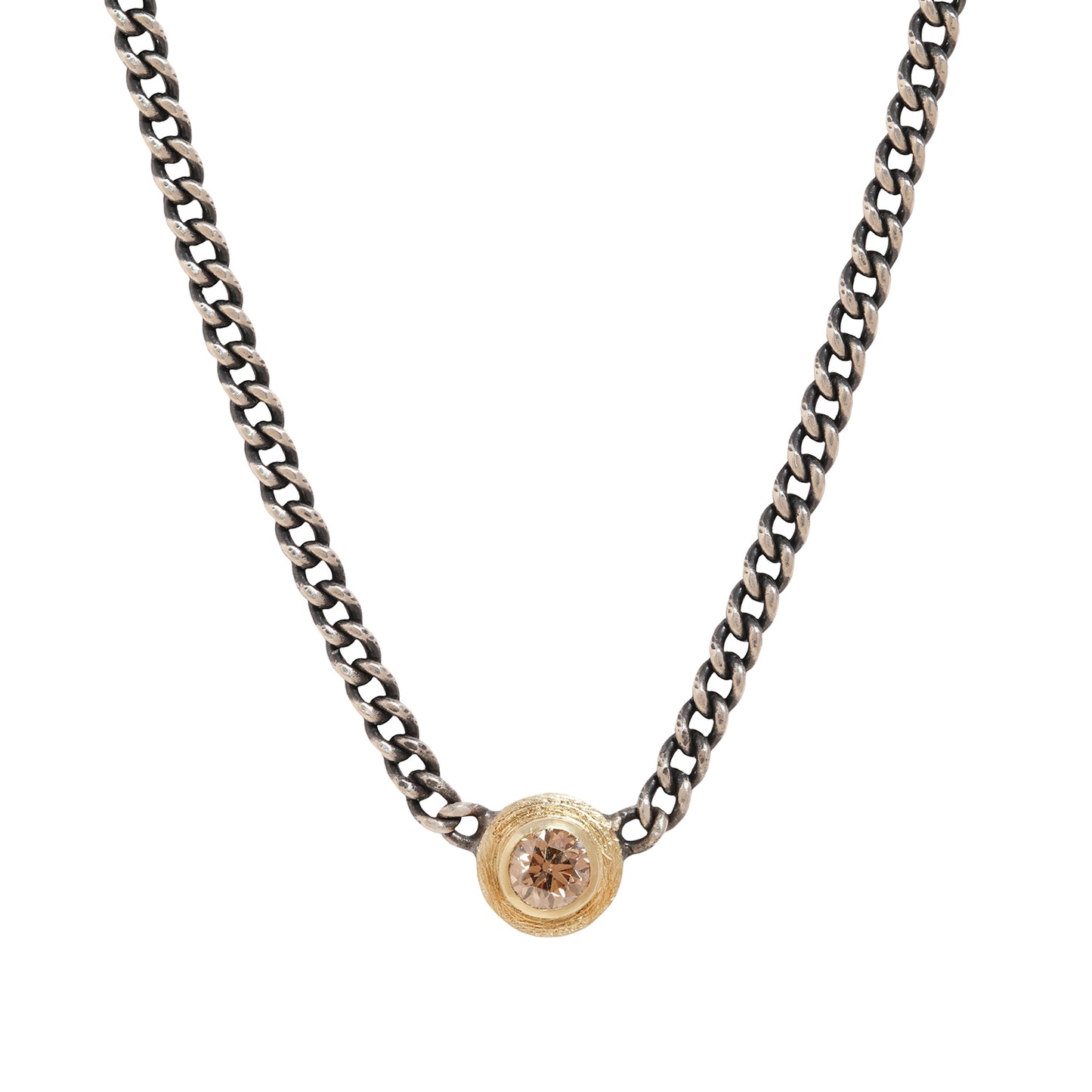 A silver-toned curb chain necklace featuring a small circular gold-toned pendant with a clear faceted gemstone, shown against a plain white background.