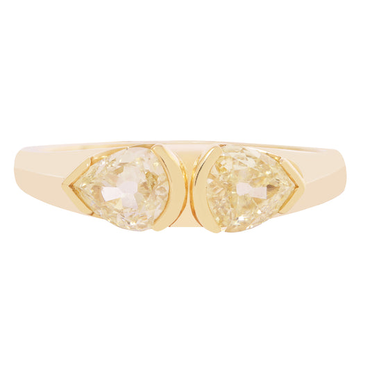 Gold ring with two pear-shaped gemstones on a white background