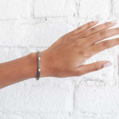 Rene Escobar - Hand wearing a bracelet on a textured white background