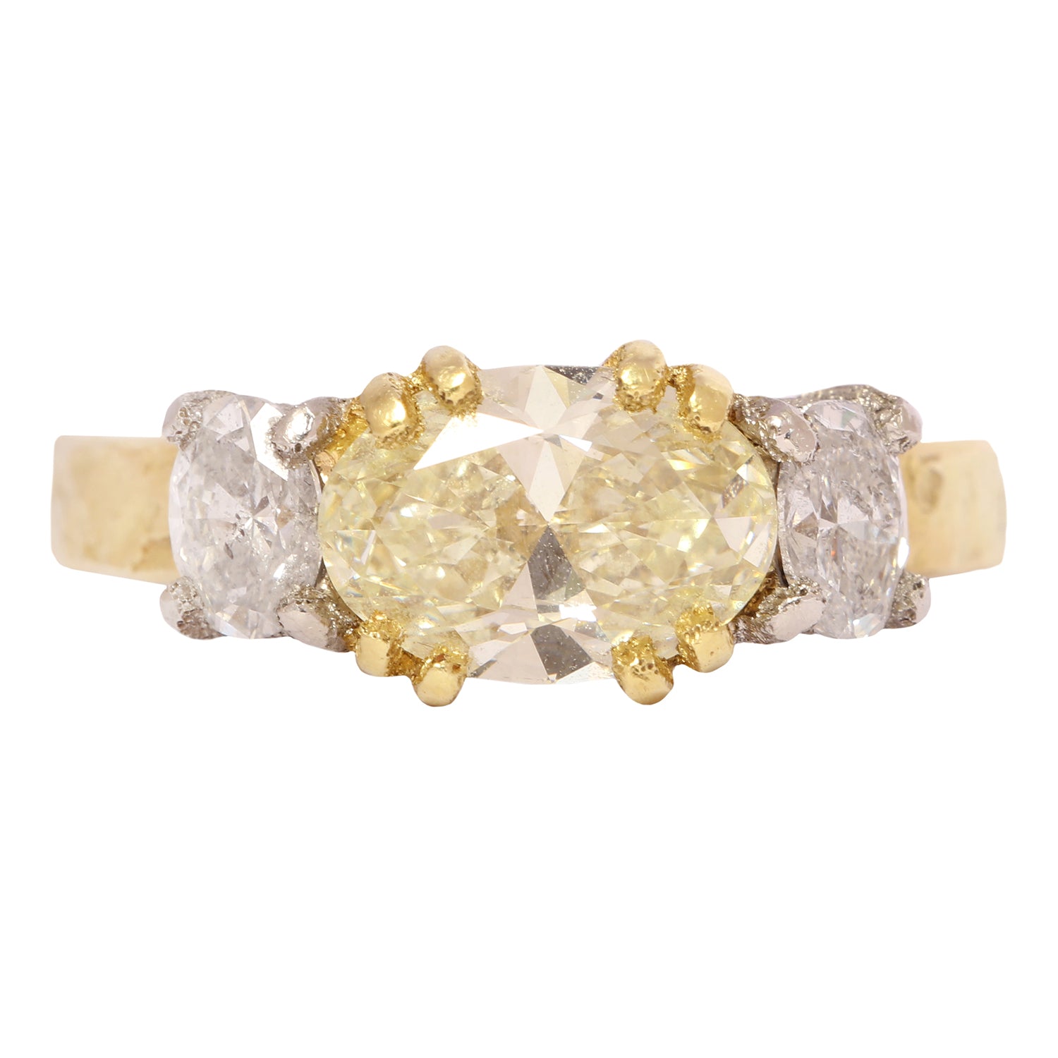 Gold and platinum ring with a central yellow diamond and smaller diamonds on a white background