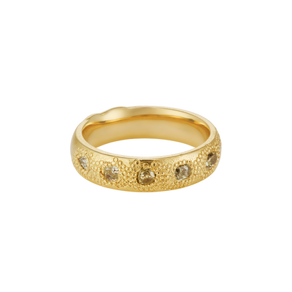 A textured yellow gold band ring featuring a row of small, round-cut green-colored diamonds set along the front, shown against a plain white background.