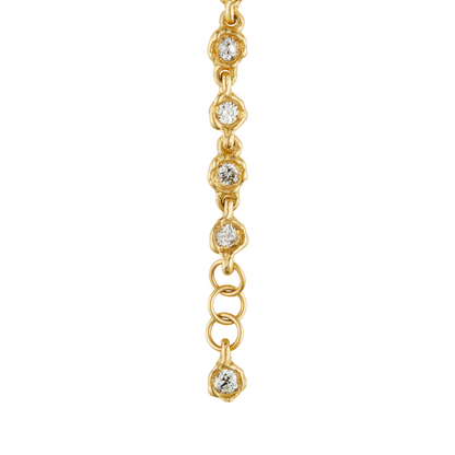 A gold chain bracelet featuring a vertical line of small, round bezel-set clear gemstones on a plain white background.