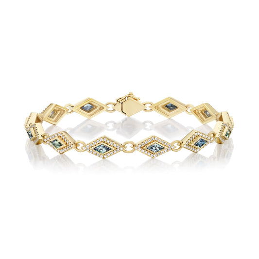 Gold bracelet with embedded blue stones on a white background